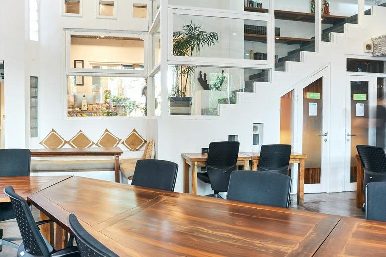 Spacious shared workspace at Jalan Raya Nyuh Kuning with warm wood finishes and high ceilings.