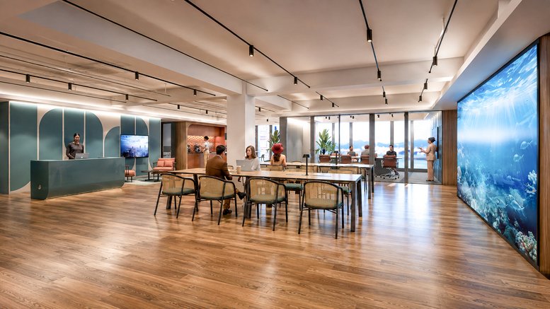 Spacious reception and lounge at 88 Connaught Road Central with wood floors and digital art wall.