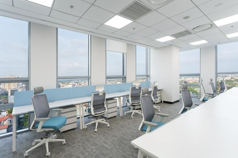 Spacious workspace with rows of desks and blue privacy dividers overlooking the city.