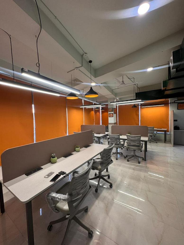 Open workspace with pendant lighting and multiple desk setups.