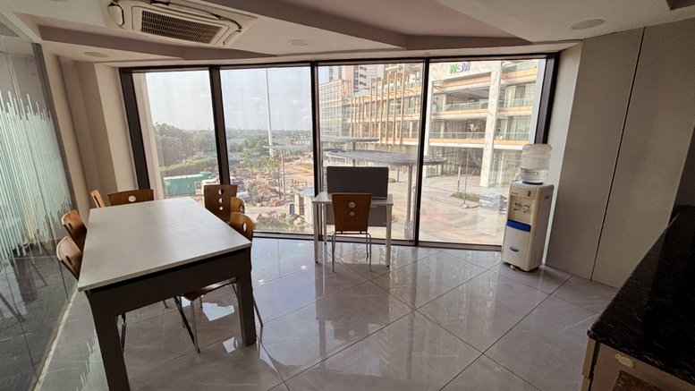 Spacious communal dining area at M3M 113 Market with floor-to-ceiling windows and city views.