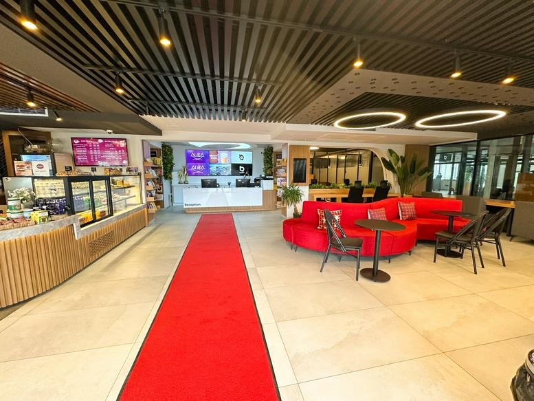 Spacious reception area with a red carpet and curved sofa at Namık Kemal Caddesi, No: 57/A.