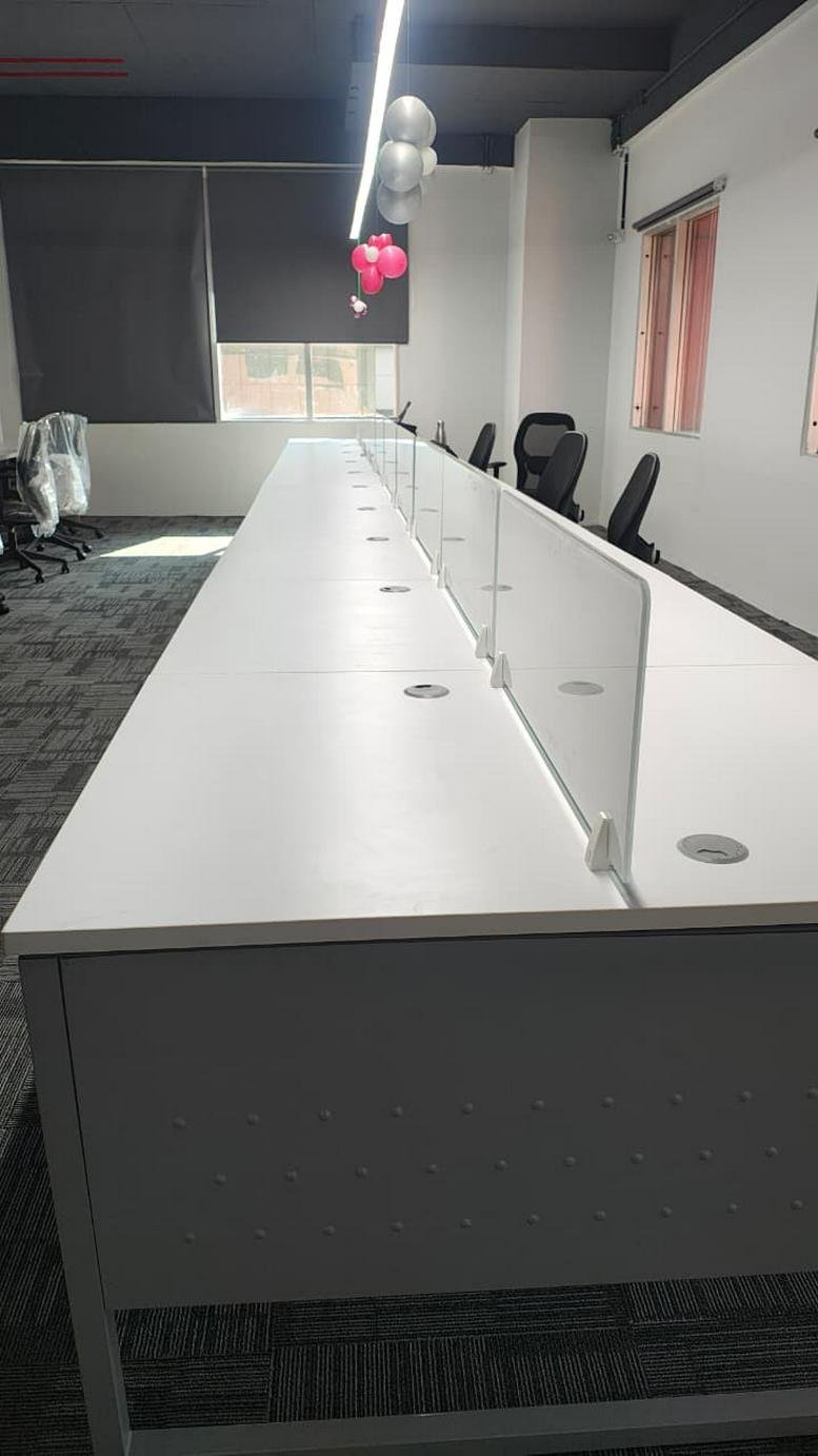 Long open-plan workspace at No, 33. 2nd Floor, Rasathi Kalaignar Nagar with white desks and glass dividers.
