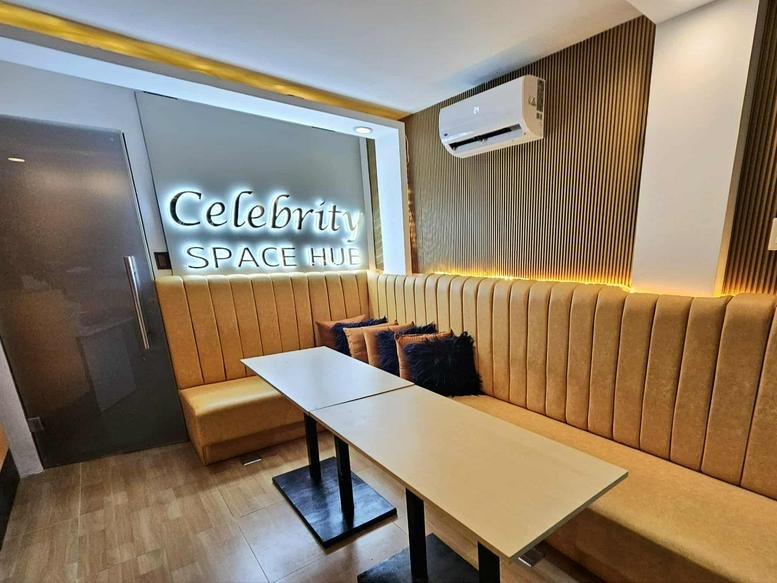 Communal lounge at 115, Mother Ignacia Avenue, Diliman with yellow tufted bench seating and a light wood table.