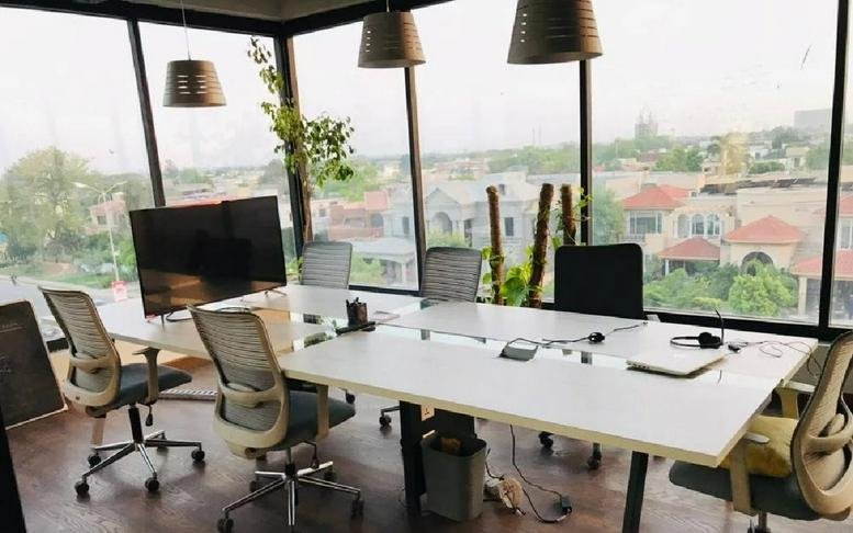 Spacious open-plan workspace at Shabbir Sharif Road, Phase 6, DHA, Lahore with floor-to-ceiling windows and city views.