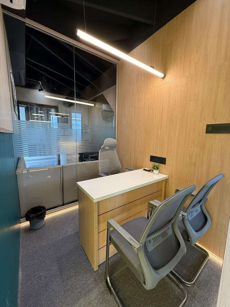 Internal two-person office at Suvidhi Signature with wooden paneling and glass partitions.