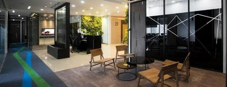 Spacious reception and lounge at 23F Penhouse Plaza Marein with modern furniture and a green moss feature wall.