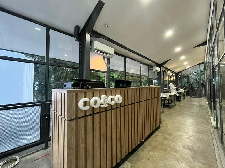 Wooden-slat reception desk with white logo at 33, Jalan Dipati Ukur, Bandung.