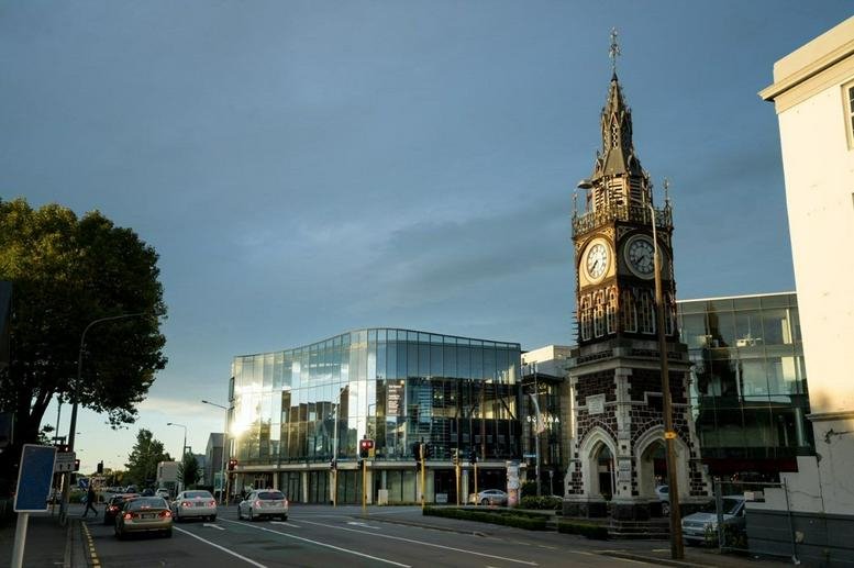 Exterior view of the glass-facade building at 47/49 Salisbur Street next to the historic clock tower.