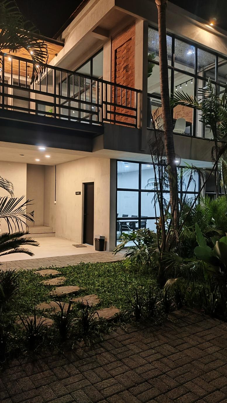 Night view of the multi-level glass and concrete building at 66, Jalan Danau Poso, Denpasar.