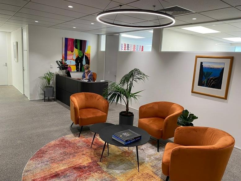 Reception area at Building 10 Level 3, 666 Great South Road featuring orange chairs and colorful abstract art.