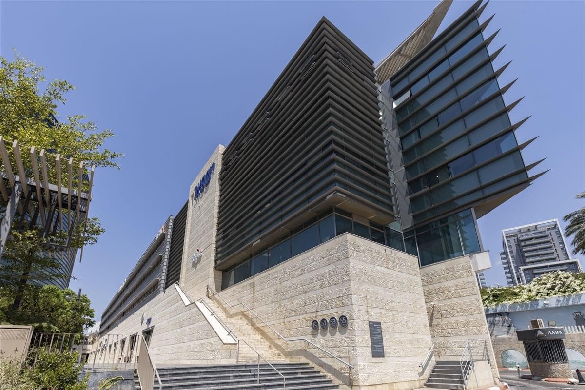 Exterior view of the modern glass and stone building at 7 Sapir Street, Herzliya.