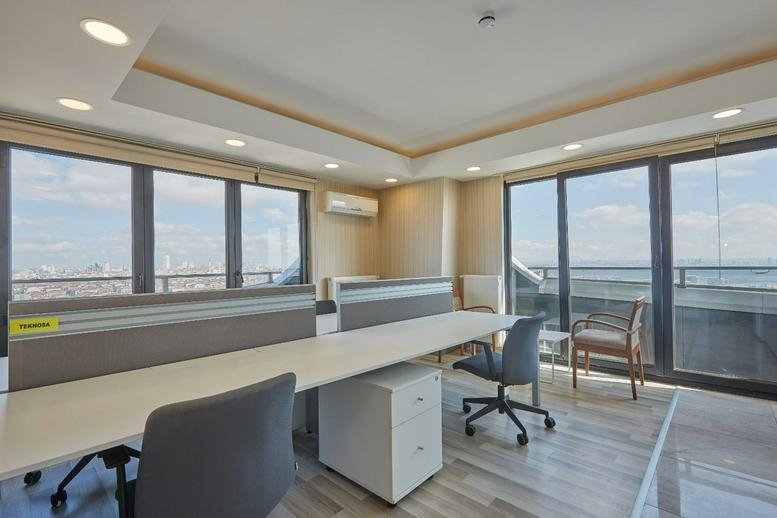 Bright, spacious open-plan workspace with large windows offering panoramic city views.