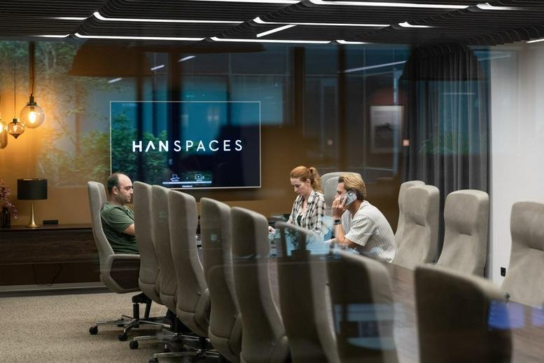 Meeting room at Nida Kule featuring a glass wall, long table, and large digital screen.