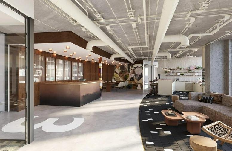 Spacious reception and lounge at Beit Rubinstein with industrial ceilings and a large '3' floor graphic.