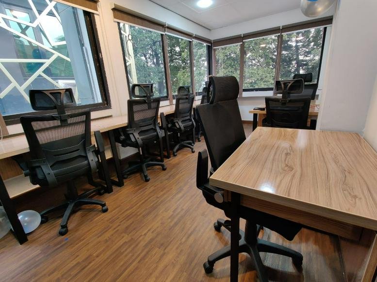 Bright open-plan workspace with multiple desks and natural light from windows.