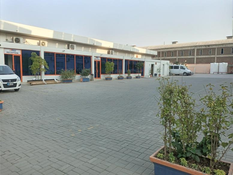 Landscape exterior view of the building facade and paved entrance area.