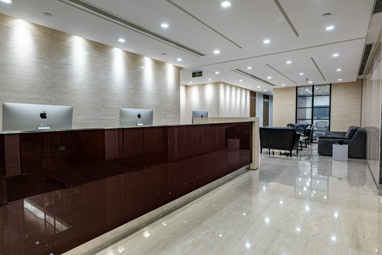 Professional reception area with a dark wood desk and warm recessed lighting.