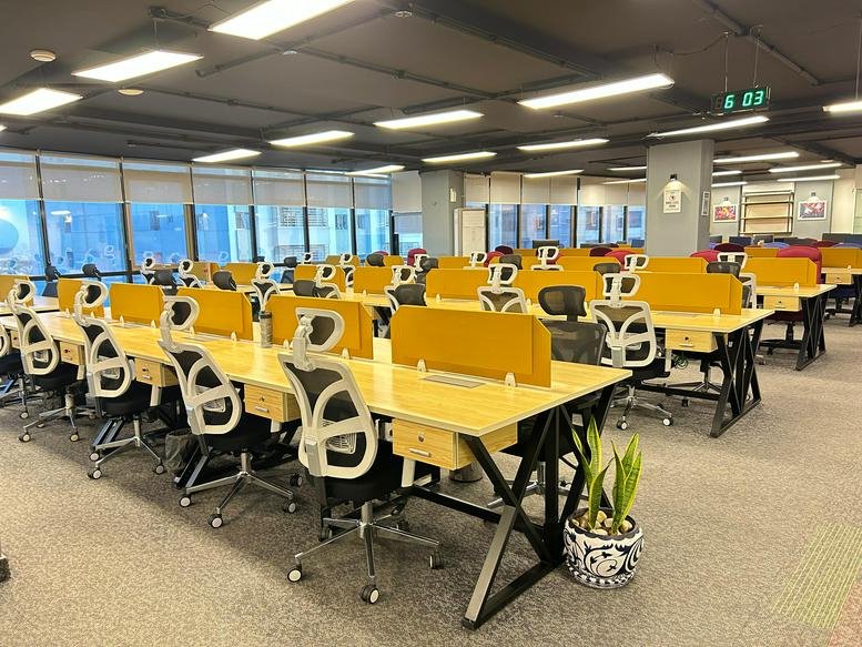 Large open-plan office with yellow desk partitions and ergonomic chairs.