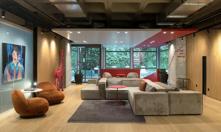 Spacious lounge area at Ferko Signature with modular sofas, velvet armchairs, and a decorative red giraffe.
