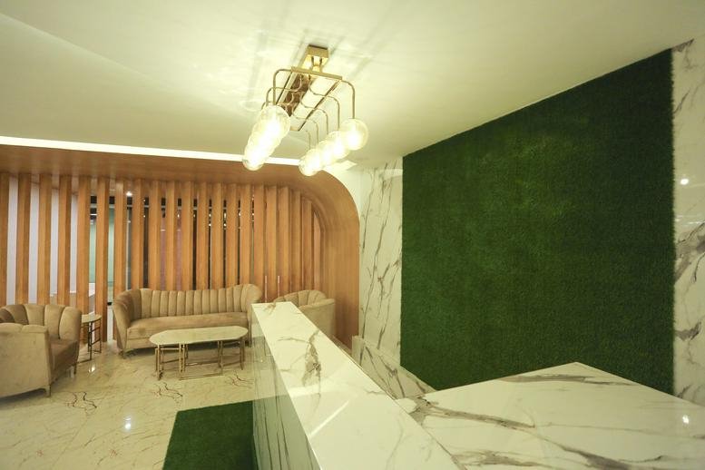 Reception lobby at Central Mall on Grand Trunk Road with marble desk and artificial turf wall.