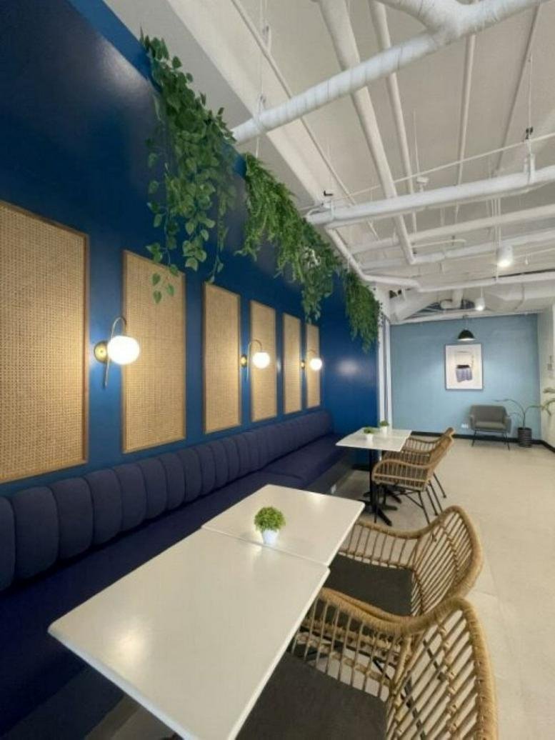 Communal lounge at Five E-Com, Mall of Asia Complex featuring navy blue banquet seating and cork wall panels.