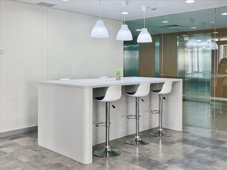 Communal breakout area with high-top seating and pendant lighting.