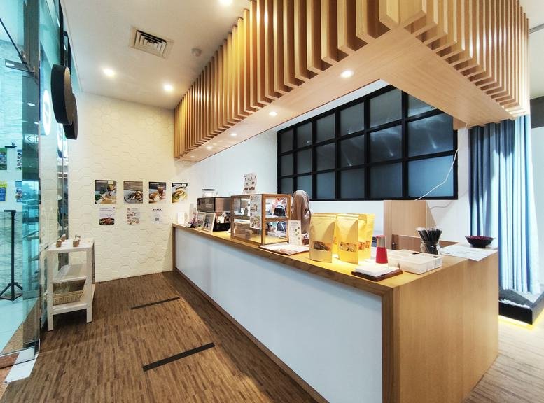 Cafe and reception area at Jalan Jend. Sudirman kav 3 with wooden slat ceiling and bright counter.
