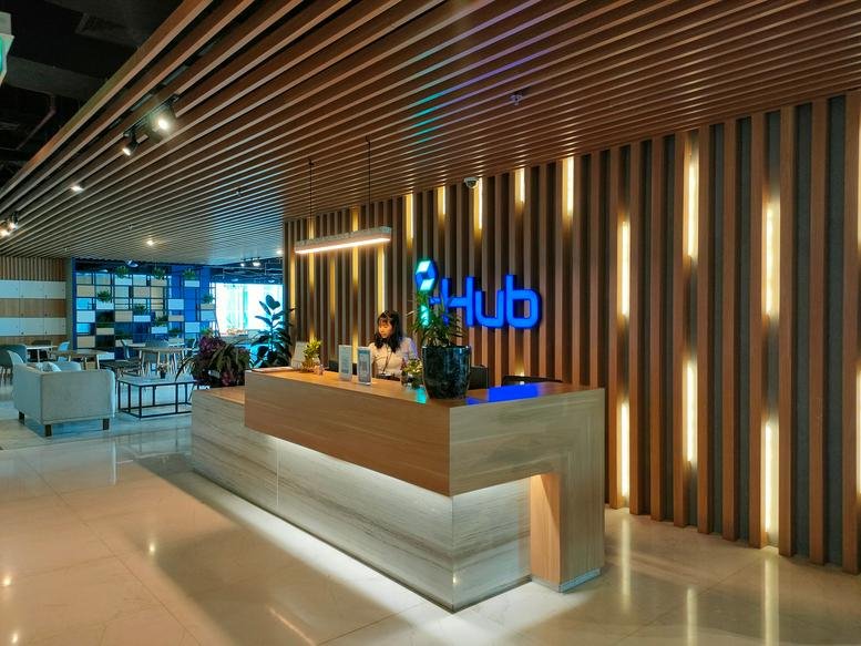 Bright, modern reception at Park Tower with a wooden slatted ceiling and warm accent lighting.