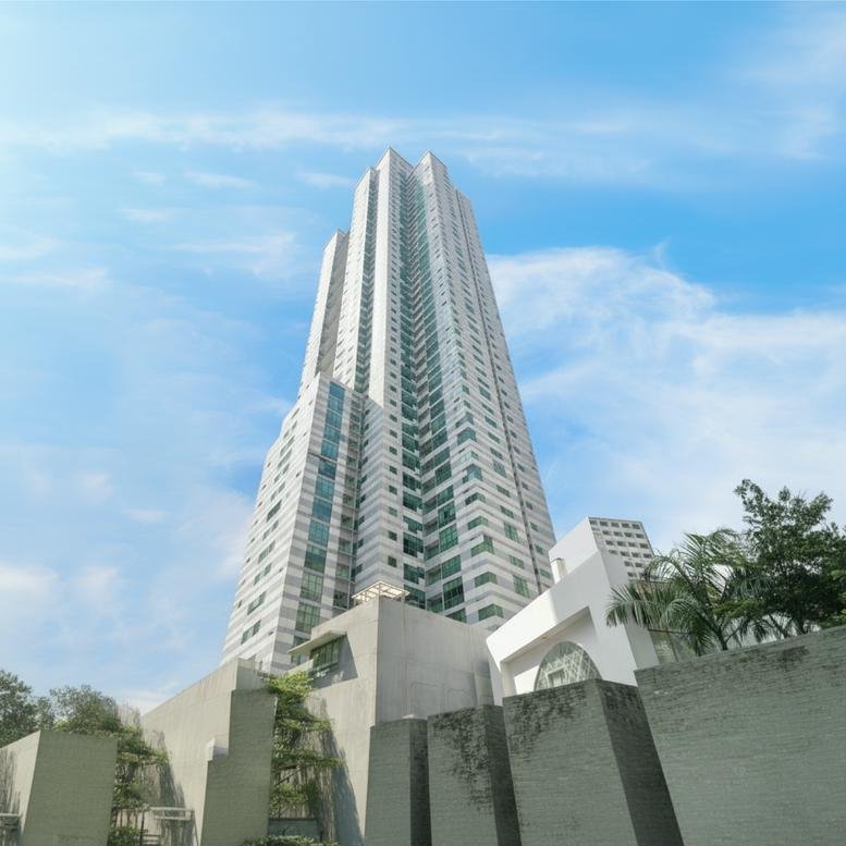 Exterior view of the soaring glass and concrete Menara Batavia tower against a blue sky.