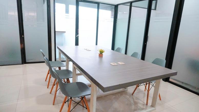 Meeting room at Jl. Arumba No. 7, RT. 001/RW. 004, Tunggulwulung with glass walls and a large wooden table.