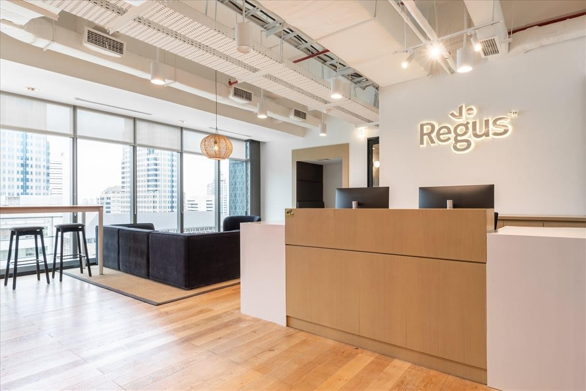 Bright reception area featuring a wooden desk and branded white wall.