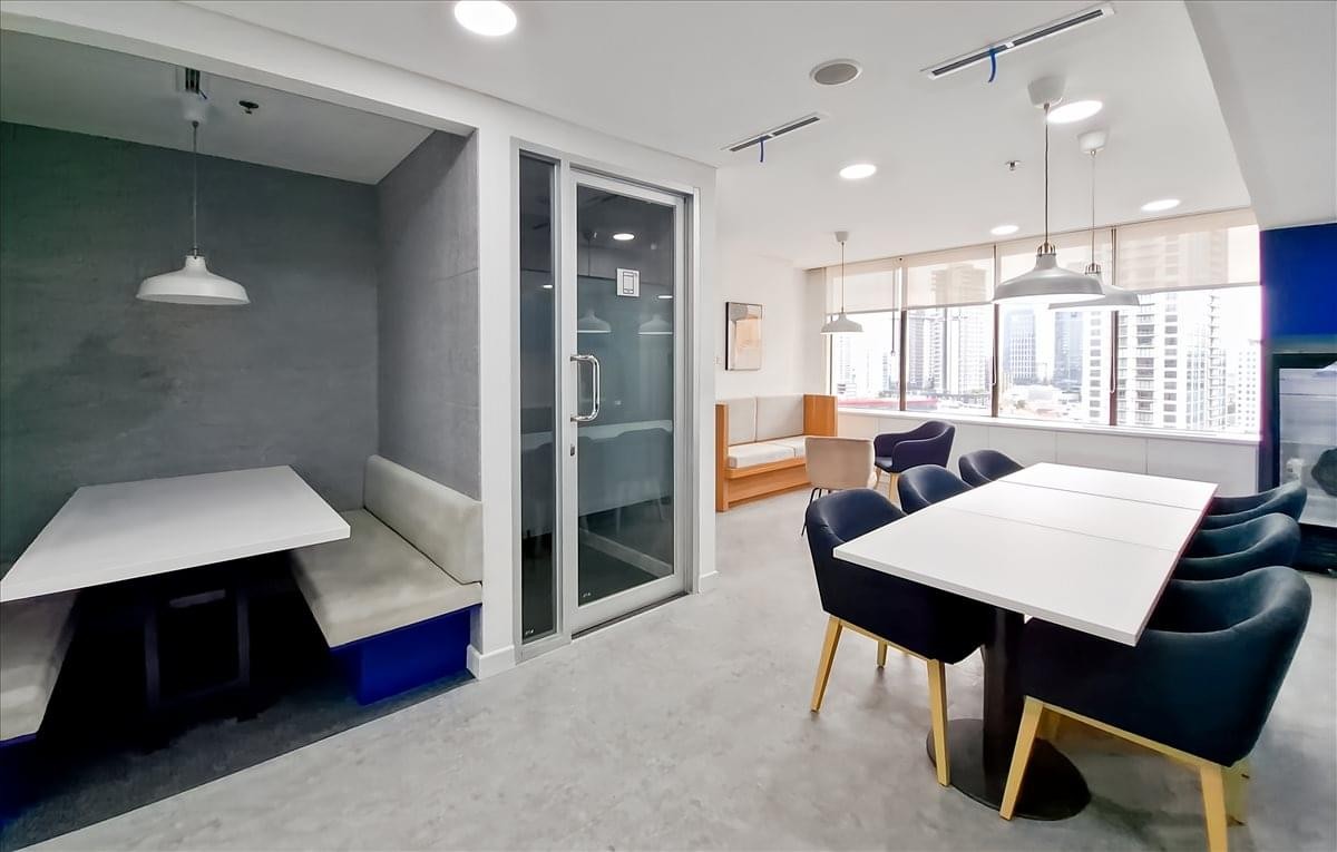 Spacious communal dining area and lounge at Menara Cakrawala with blue seating and modern lighting.