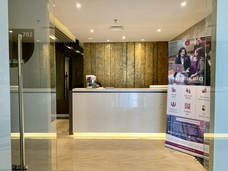Bright reception desk at Plaza Summarecon Level 7 featuring a textured gold feature wall.