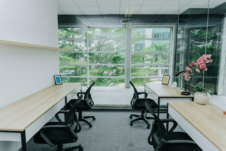 Spacious office with large windows overlooking trees at The Honey Lady Tower.