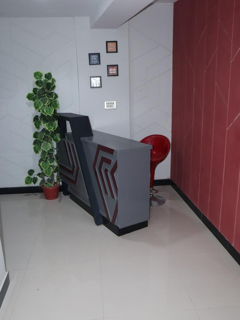 Reception area at Karachi Center featuring a modern grey desk and a vibrant red feature wall.