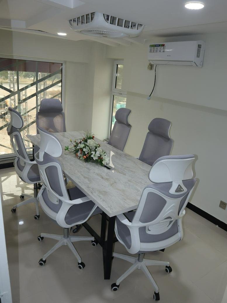 Meeting room at Karachi Center with a marble-topped table and ergonomic mesh chairs.