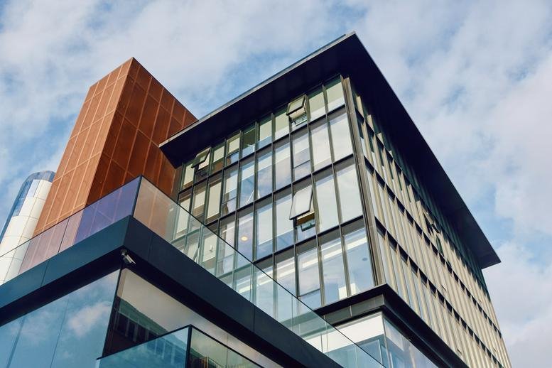 Exterior view of the contemporary glass and wood facade of the Nisbetiye office building.