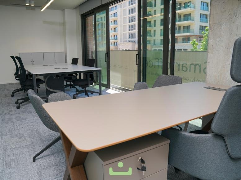 An office area at No: 54 M1 M2 M3 M4 Blok Zeytinburnu with collaborative desks and floor-to-ceiling windows.