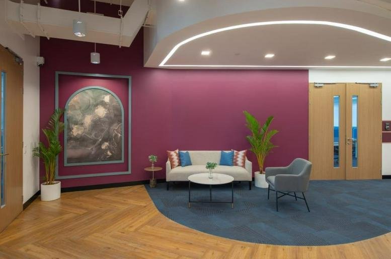 Spacious reception lounge at SM North EDSA Tower 1 with purple feature wall and curved lighting.