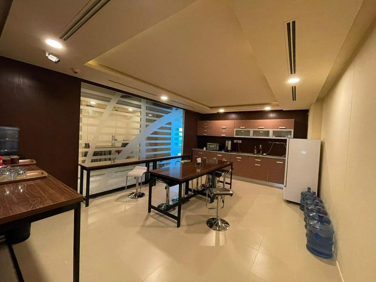 Spacious communal kitchen and dining area at ISE Tower with wooden tables and a breakfast bar.