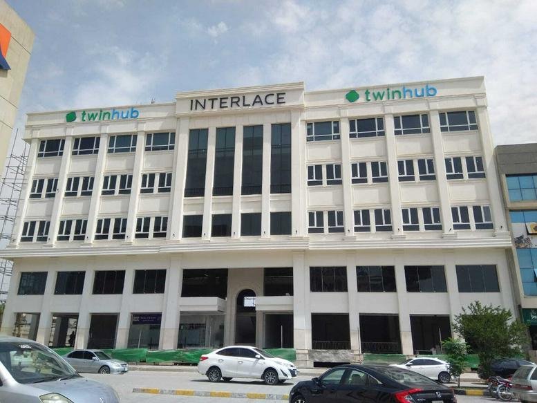 Exterior view of the white classic-style INTERLACE building in Islamabad.