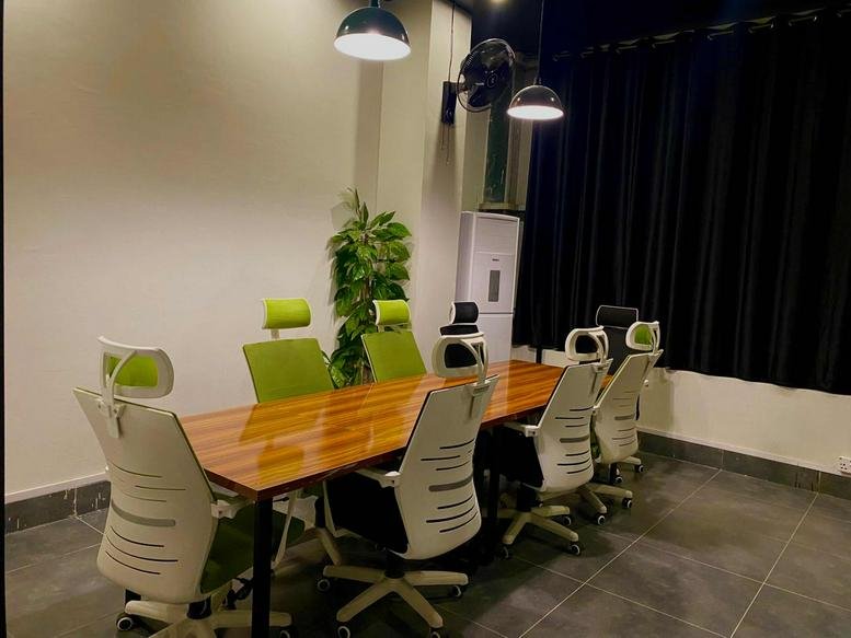 Conference room at Pakistan Town Phase 1, Al Taqwa Mall, featuring a wood table and white ergonomic chairs.