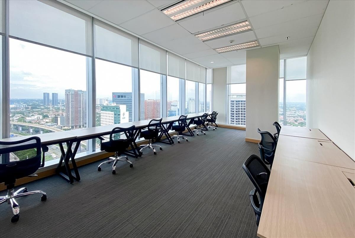 Spacious open-plan workspace at Palma Tower with long window-facing desks and expansive city views.