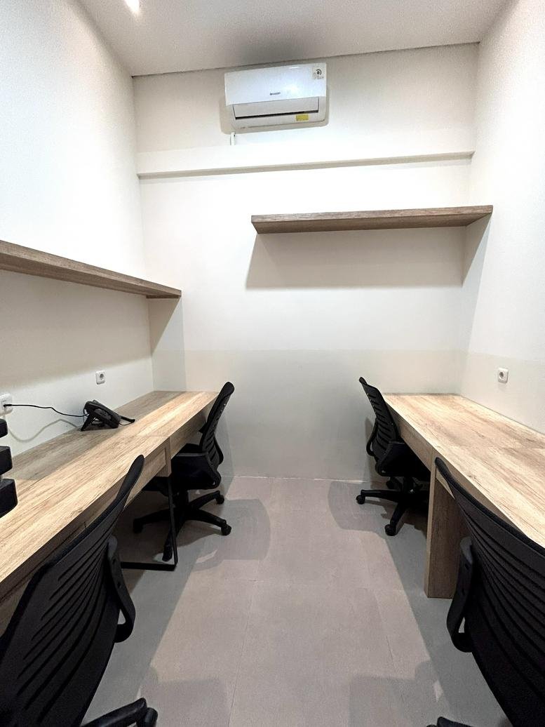 Private four-person office suite at Promenade Canggu with wooden desks and air conditioning.