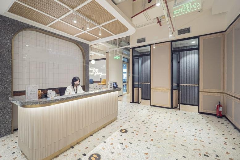 Modern reception area of Sampoerna Strategic Square with a white fluted desk and warm lighting.