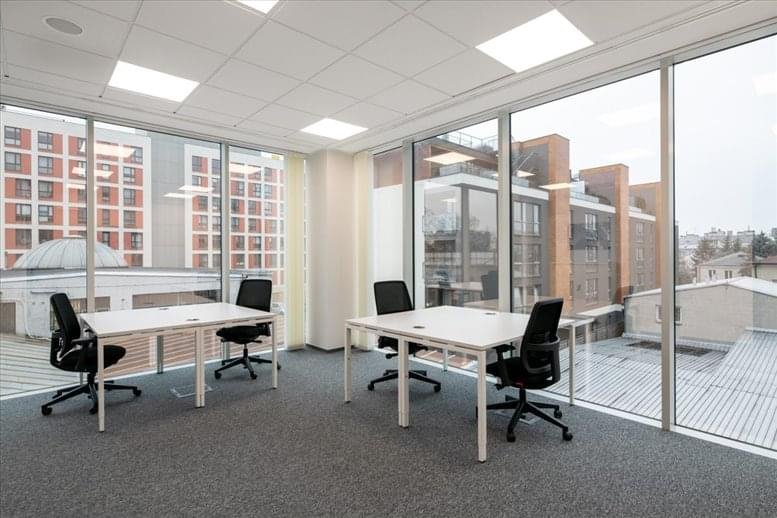 Interior three-person office with large windows and city views.