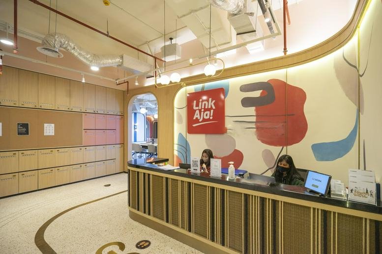 Bright, branded reception area at Treasury Office Tower with a modern wood-slat desk and colorful wall art.