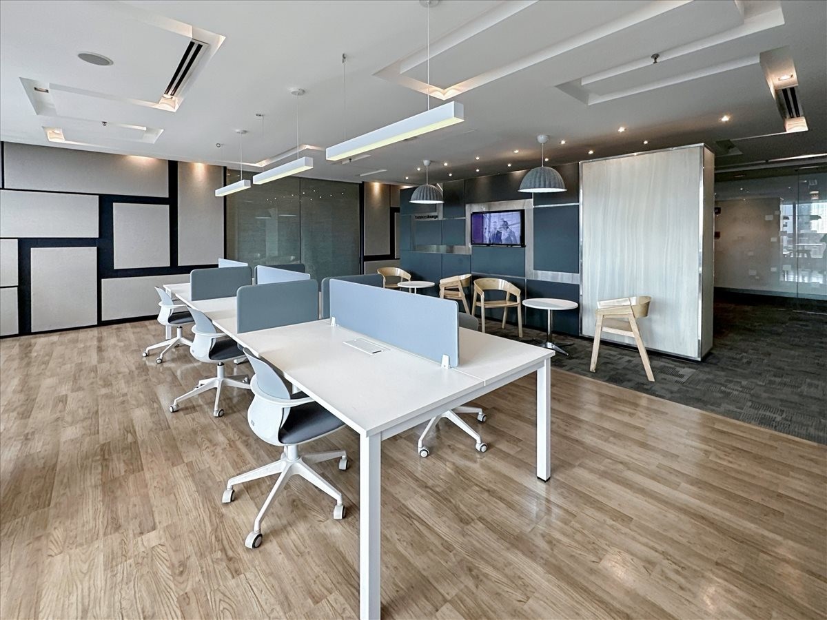 Spacious open-plan workspace at Victoria de Makati featuring white desks and blue privacy dividers.