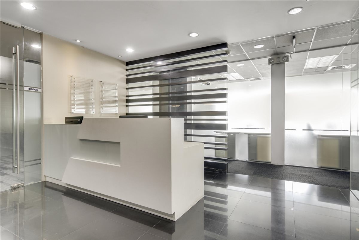 Modern minimalist reception desk with a unique horizontal slat backdrop and polished floors.